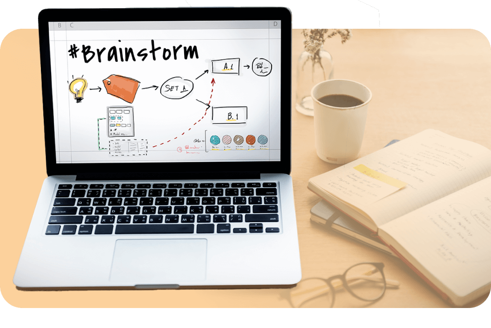 Laptop mit einer Brainstorming-Sitzung auf dem Bildschirm, neben einer Tasse Kaffee und einem Notizbuch, was eine kreative Planungsphase symbolisiert