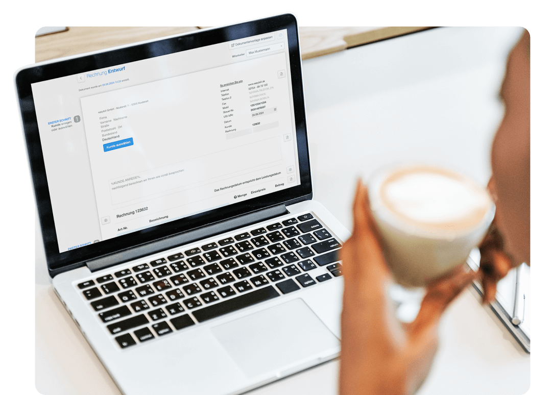 Person nutzt easybill Software zur Erstellung von Rechnungen auf einem Laptop, mit detaillierter Ansicht des Rechnungsentwurfs und einer Tasse Kaffee in der Hand.